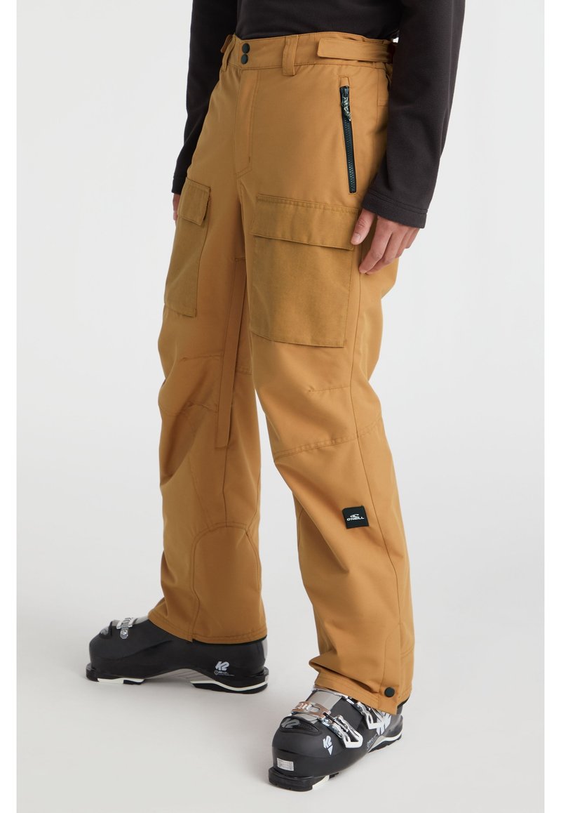 Braune isolierte Cargo-Hosen mit mehreren Taschen, verstärkten Knien und einem eleganten Design, kombiniert mit schwarzen Skistiefeln.