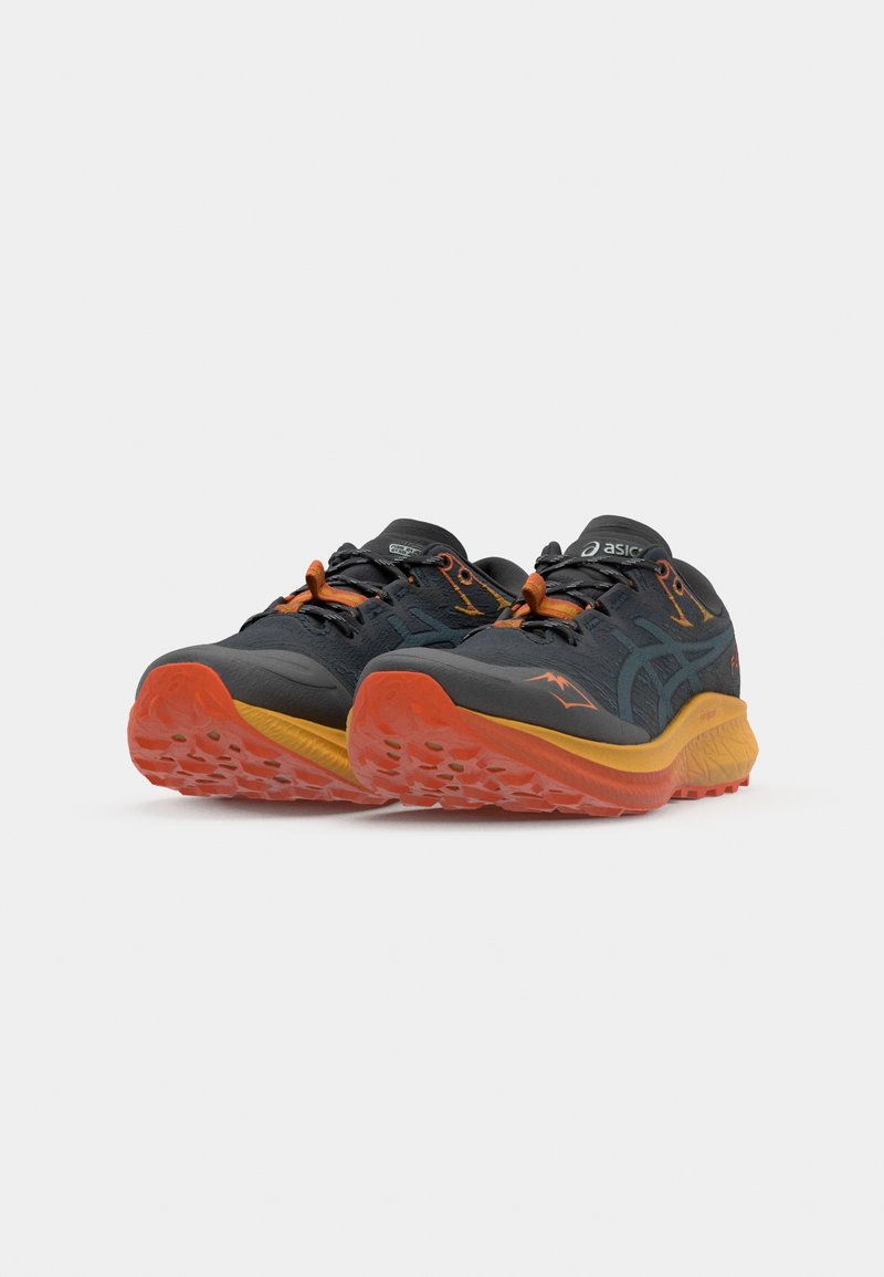 Baskets de sport noires et grises avec des accents orange. Présentent une tige texturée, une semelle rembourrée et une semelle intermédiaire jaune contrastante.