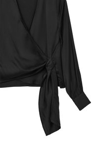 Top avvolgente nero realizzato in un tessuto liscio, con maniche lunghe, un dettaglio laterale legato e una scollatura a V. I polsini sartoriali completano il look.