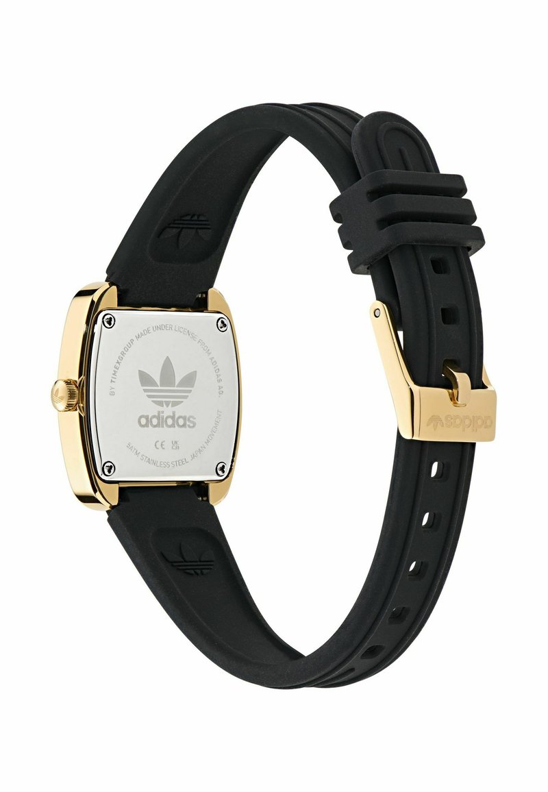 Vierkant horloge met een kast van metaal in goudkleur en een zwarte siliconen band. Heeft een logo op de achterkant en een veilige metalen gesp.