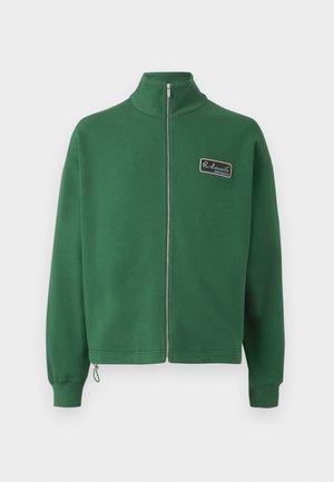 Green zip-up sweatshirt with stand collar, crafted from soft fabric, featuring a small brand patch on the left chest and ribbed cuffs.