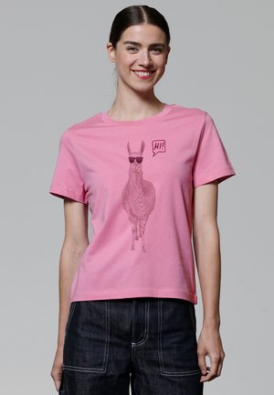 T-shirt en coton rose avec un graphique d'un lama portant des lunettes de soleil, avec le mot "Salut !" dans une bulle de dialogue. Manches courtes et col rond.