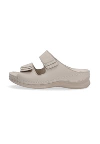 Beige leren slipper met twee verstelbare klittenbandriemen, gebogen ontwerp en een gevoerde zool met antislip oppervlak.