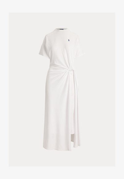 Λευκό μίντι φόρεμα με κοντά μανίκια, στρογγυλή λαιμόκοψη, δεσίματα στο πλάι και μικρό κεντημένο λογότυπο σε ναυτικό μπλε χρώμα στο στήθος.