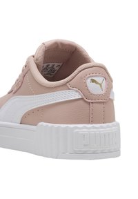 Sneaker in pelle rosa chiaro con accenti bianchi, suola texturizzata e etichetta con logo Puma sul tallone. Punta tonda e suola intermedia spessa bianca.