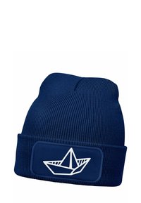 Navy knit beanie featuring a white paper boat design on a rectangular patch. Ribbed texture and fold-over cuff for added warmth.