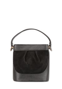 Sac à main noir combinant du cuir lisse et du daim doux, avec une forme structurée, une courte poignée et un subtil détail de plissés.
