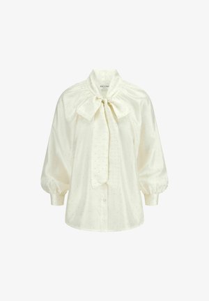 Witte blouse van gladde stof met pofmouwen, een strikboord, en kleine decoratieve stippen over de gehele blouse. Voorzijde met knoopsluiting.