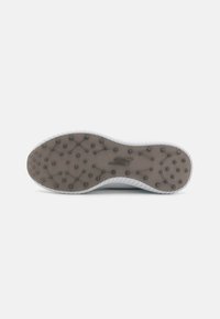 Fehér sneaker talp textured gumival és körkörös tapadási mintázattal, sima szélekkel és diszkrét logóval a középső rész közelében.