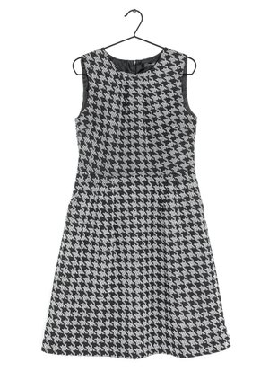 Robe sans manches à motif pied-de-poule noir et blanc avec encolure ronde, taille cintrée et jupe évasée, suspendue à un cintre noir.