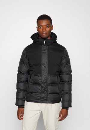 Svart puffjacka med huva, med dragkedja framtill, quiltad textur och sidofickor. Slät yta och justerbara funktioner.