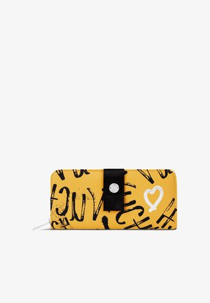 Yellow wallet with black graphic lettering, featuring a white heart design and a black ribbon accent. Smooth material with a zip closure.