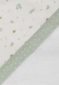 Tela de algodón suave con un fondo color crema claro, que presenta patrones de animales y botánicos en color verde menta. Con borde en color verde menta.