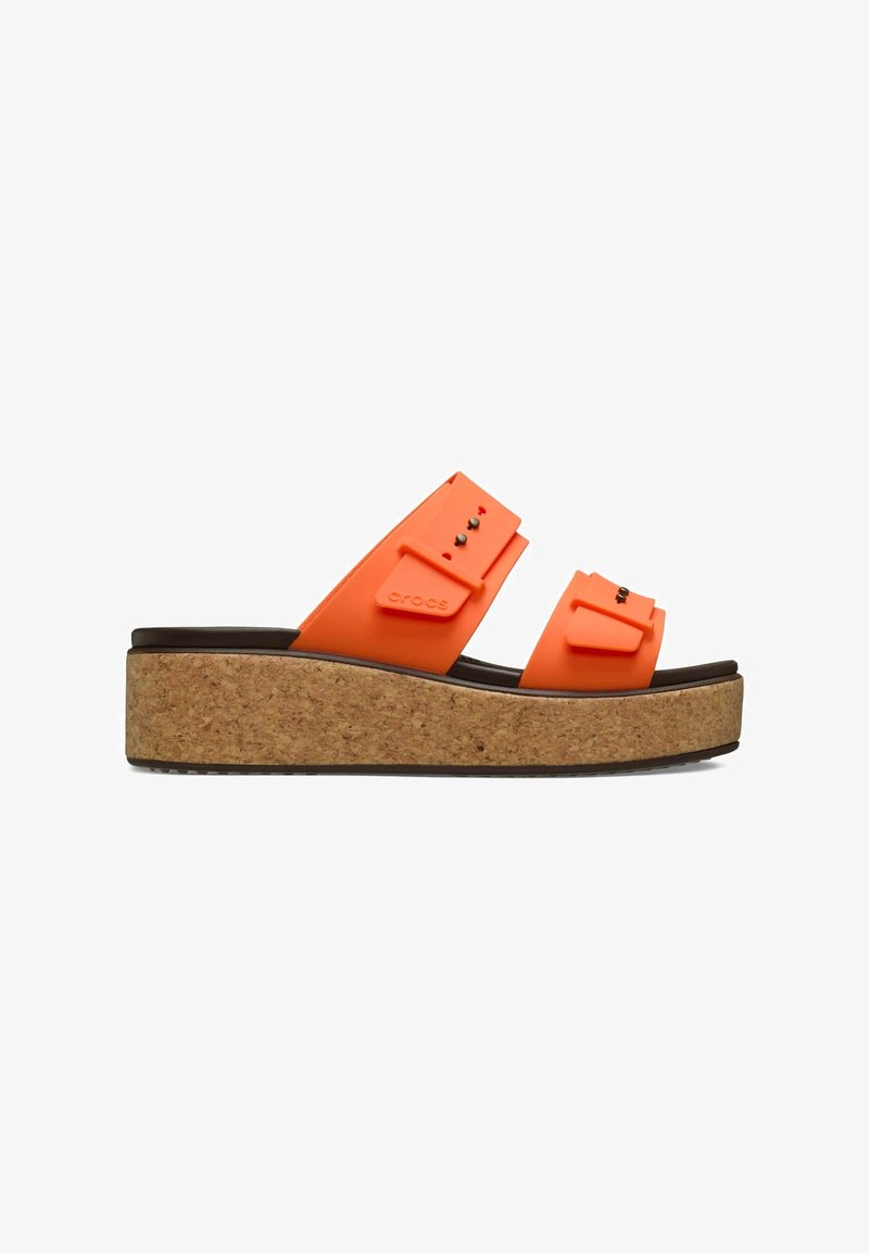 Orangefarbene Gummiplattformsandalen mit zwei breiten Riemen, die mit Verzierungen ausgestattet sind; Kork-Zwischensohle und strukturierte schwarze Außensohle.