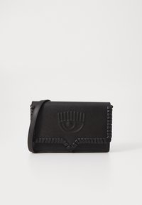 Black leather crossbody bag with embossed eye design, textured trim, magnetic closure, and an adjustable strap. Compact rectangular shape.