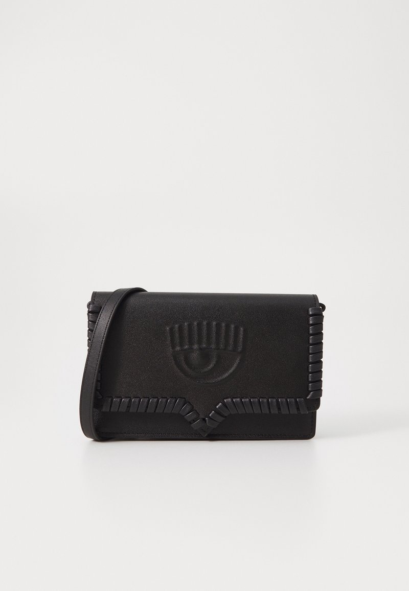 Černá obdélníková kožená crossbody taška s reliéfním motivem oka a propleteným lemováním, umístěná na jednobarevném bílém pozadí.