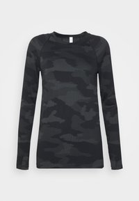 Camisa camuflada preta de manga longa com textura canelada, decote redondo e mangas raglan. Tecido leve com padrões variados em cinza escuro.