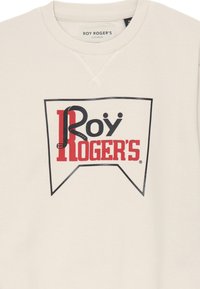 Felpa bianca con scollo rotondo, caratterizzata da una grande grafica audace in testo nero e rosso "Roy Roger's" all'interno di un design bordato.