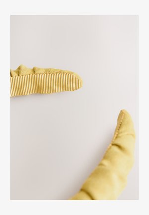 Gele stoffen handschoenen met een gestructureerd, geribd patroon op de vingertoppen, voorzien van een zacht, gebogen ontwerp en gladde naden.