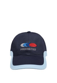 Casquette de baseball bleu marine avec des bordures de visière bleu clair, comportant trois ovales superposés en gris, bleu et rouge au-dessus du mot « PROHIBITED ».