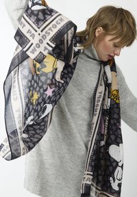 Écharpe multicolore avec des personnages de style bande dessinée et du texte. Tissu léger et transparent avec des motifs et des bordures sombres.