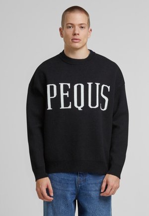 Black sweater with a round neck and oversized fit, featuring the word "PEQUS" in white knitted lettering on the front.