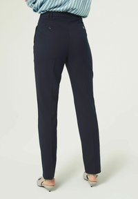 Marineblauwe tailored broeken met een slim fit, achterzakken met knopen en een gladde textuur, eindigend boven de enkel.