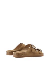 Sandali in suede marrone con due fibbie oversize in argento, design open-toe e una suola testurizzata simile al sughero, dotati di una ampia soletta.