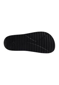 Semelle de chaussure en caoutchouc noir avec un motif texturé, présentant des stries et des rainures pour l'adhérence, et une empreinte de logo près du talon.