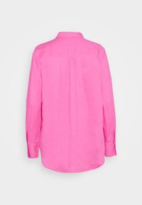 Langärmliges, kragenloses Hemd aus leuchtend pinkem Leinen. Die Rückansicht zeigt eine Mittelnähten und Manschetten mit Knopfdetails. Glatte Textur.
