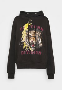 Svart hets med ett tiger grafik och gula stänk. Har lila texten "EASTERN DIVISION". Dragkedja i huvan och ribbade muddkanter. Mjuk textur.