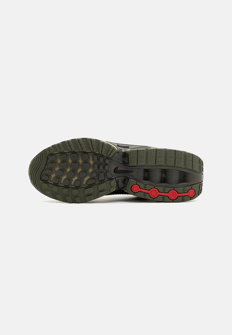 Suela de zapatilla Nike con una parte inferior de goma verde oliva, patrón de agarre texturizado y acentos rojos cerca del talón.