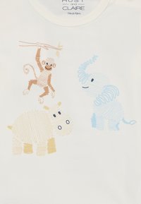 Chemise en coton blanche avec un singe brun suspendu à une branche, un hippopotame beige et un éléphant bleu clair, le tout dans un style croquis.