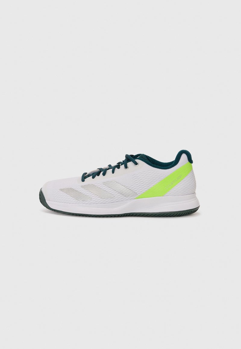 White athletic shoe with a textured mesh upper, green accents on the heel, and three metallic silver stripes on the side. Rubber sole.