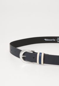 Cintura in pelle blu navy con fibbia in metallo argentato, caratterizzata da due strisce decorative: una color crema chiaro e una blu scuro. Texture liscia e design minimale.