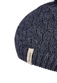 Close-up of dark blue knit woolen beanie with textured cable pattern and a beige fabric tag labeled "Stöhrdal".