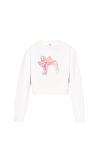 Fehér, rövidített pulóver, amelyen egy kutyát ábrázoló grafika látható, rózsaszín masnival. Az anyag puhanak tűnik, bordázott mandzsettával és szegéllyel.