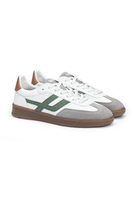 Zapatillas blancas y grises con acentos verdes, que presentan una parte superior de ante texturizado y un detalle en el talón de color marrón, con cordones planos y una suela de goma.