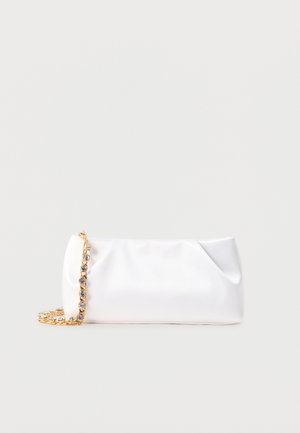 Weiße weiche Clutch-Tasche mit goldener Kettenriemen, verziert mit klaren Edelsteinen, vor einem einfarbigen hellgrauen Hintergrund.