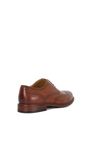 Chaussure oxford en cuir marron avec des détails de brogue perforés, bout rond et un talon en bois empilé. Texture lisse, design classique.