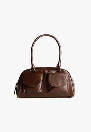 Braune Lederhandtasche mit zwei Vorderklappen, abgerundeten Griffen und einem Reißverschluss an der Seite vor einem weißen Hintergrund.