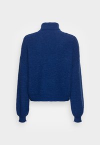 Pull cropped bleu avec un col haut, des manches longues et un motif en maille texturée. Tissu doux avec des poignets et un ourlet côtelés.
