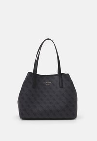 Sac fourre-tout noir Guess avec double anses, motif de logo répété et "GUESS Est 1981" imprimé en or au centre avant.