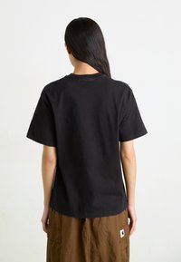 Svart bomull t-skjorte med korte ermer, rund hals og en avslappet passform. Stoffet ser mykt ut, uten synlige mønstre.