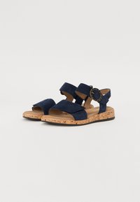 Merineid suede sandaalid korkkistsööliga, millel on kaks laia rihma ja reguleeritav pandla, millel on kettakinnitus.