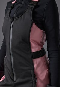 Zwarte en roze sportkleding met een ritssluiting aan de voorkant, verstelbare banden, een gladde textuur en een getailleerd ontwerp. Accentuati met een gemarkeerde tailleband.