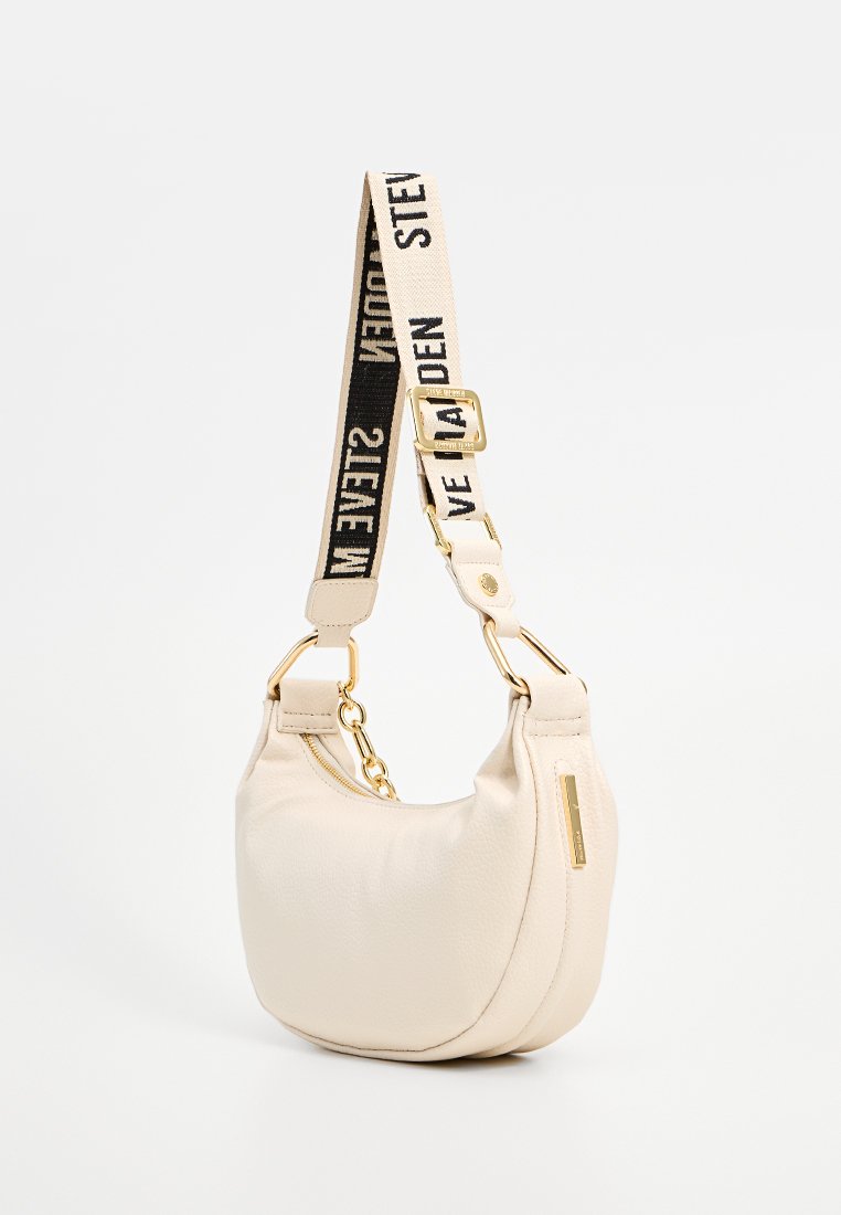 Borsa a spalla a forma di mezzaluna in crema con ampia tracolla regolabile beige e nera caratterizzata da un testo audace e dettagli in metallo color oro.