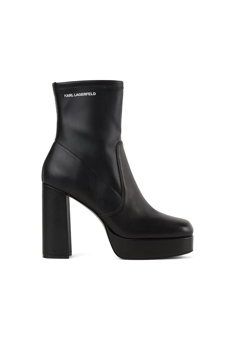 Zwarte leren enkellaars met een hoge blokhak, platformzool, zijnahtdetails en een reliëfmerk aan de bovenkant.