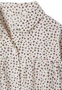 Cremfarbendes Stoffhemd mit braunem und schwarzem Leopardenmuster, durchgehende Knopfleiste und umgeschlagener Kragen.