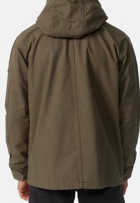 Chaqueta con capucha de color verde oliva y corte relajado, con una textura suave, puños con botones a presión y un detalle de costura central en la parte trasera.